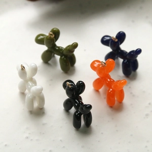 Detail of colorful resin balloon dog charms with glossy finish and gold metal loops