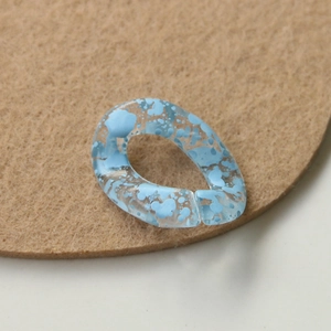 Macro view of semi-transparent sky blue acrylic links with ink spots for DIY jewelry