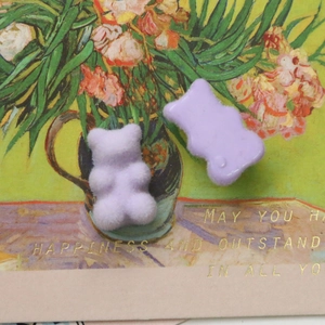 Confronto dettagliato tra ciondoli a orsetto lavanda in velluto e resina lucida