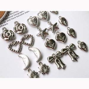 Detailed flat lay of silver vintage heart, star and moon charms for DIY jewelry making