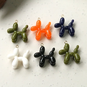 Macro detail of glossy resin balloon dog pendants with golden rings in diverse colors