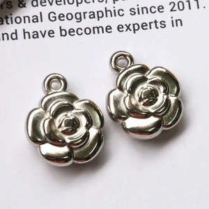 Macro shot of silver camellia flower metal charms with top rings for DIY jewelry making