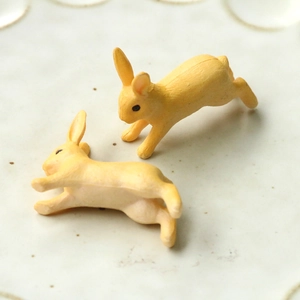 Gros plan de figurines de lapins jaunes mignons en résine sur un plateau en céramique