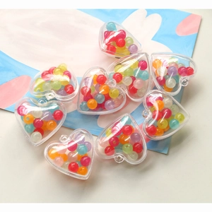 Détail de pendentifs en acrylique en forme de cœur avec des perles colorées pour bijoux DIY