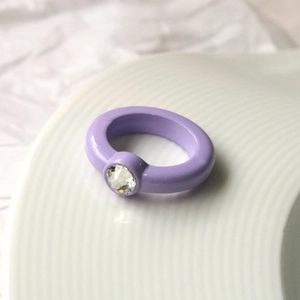 Dettaglio dell'anello in acrilico viola caramella con gemma tonda trasparente brillante