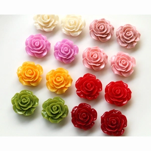 Flat lay of colorful resin rose flower charms for DIY crafts and jewelry making