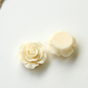 Macro view of creamy white resin rose flatback charms for DIY craft and hair accessories