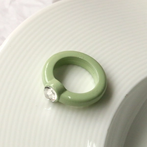 Dettaglio anello in resina verde menta con incastonato un diamante rotondo