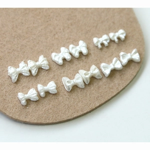 Elegant pearl white resin bow charms for nail art and DIY jewelry crafting projects