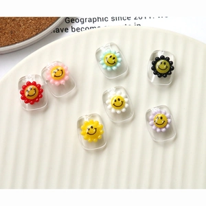 Macro shot of colorful acrylic flower smiley face beads for DIY jewelry and nail art crafts