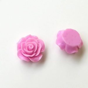 Macro detail of two pink resin rose charms showing floral texture and flat back for DIY crafts