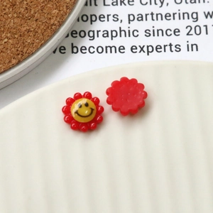 Macro shot of colorful acrylic smiley daisy charms for DIY hair accessories and crafts