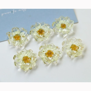 Macro detail of six handmade resin daisy flower charms with real dried floral petals