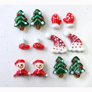Detailed macro shot of handmade glass Christmas tree, Santa, and stocking DIY beads