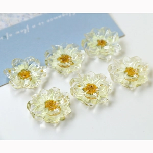 Macro shot of six transparent resin daisy flower charms with yellow center for DIY crafts