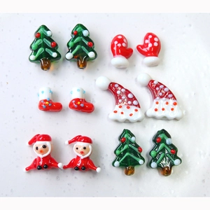 Macro shot of festive Christmas glass beads including Santa hats and trees for DIY jewelry