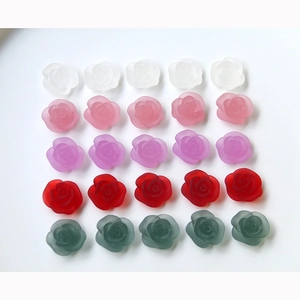 Macro view of 25 matte translucent resin rose flower cabochons for DIY crafts