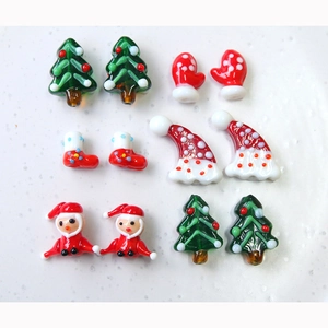 Flat lay of 12 festive Christmas themed glass charms for DIY crafts and jewelry