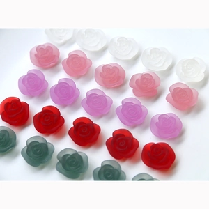 Detail view of assorted colorful matte resin rose charms for DIY jewelry and hair clips