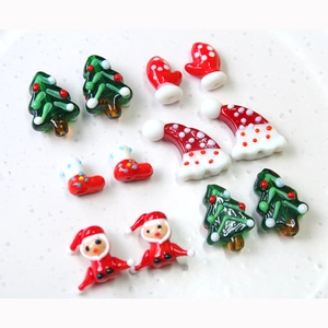 Handmade lampwork glass beads featuring Christmas tree, Santa hat, and festive socks