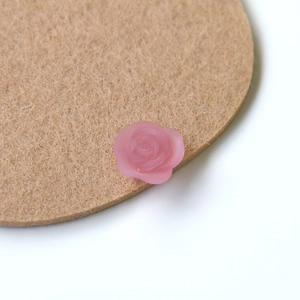 Close-up of matte pink resin rose charms for DIY jewelry and phone case crafts