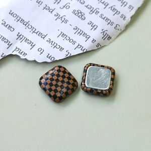 Détail macro de boutons carrés à damier avec dos en métal argenté poli pour artisanat