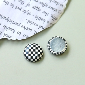 Vue macro de boutons en tissu à motif damier avec envers en métal argenté poli