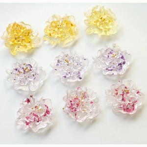 Macro detail of handmade resin flowers with dried petals and gold beads for jewelry DIY