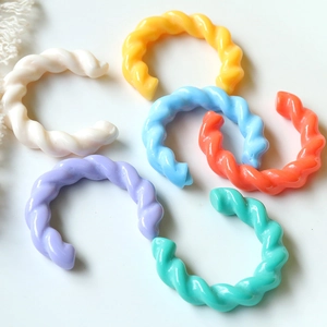 Dettaglio di sei clip per orecchie a spirale in acrilico color caramello in varie tonalità