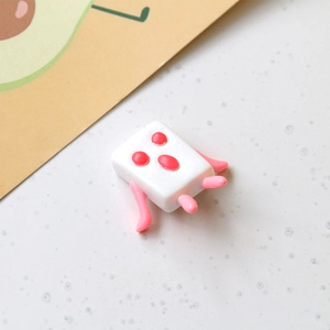 Macro shot of a cute white resin monster figurine for DIY phone case and accessory crafting