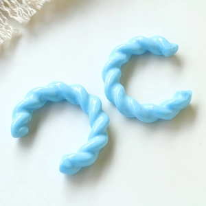 Vista macro di accessori per gioielli in acrilico a forma di C intrecciati blu cielo