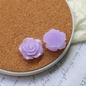 Detail of purple resin rose flatback charms with glitter finish for DIY jewelry crafts