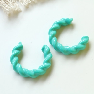 Dettaglio di orecchini a cerchio a C in acrilico blu tiffany con design a spirale ritorto