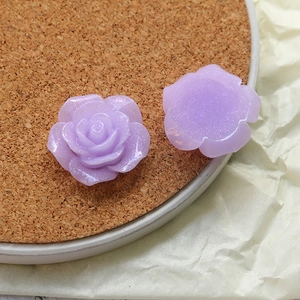 Macro detail of purple iridescent resin rose charms for DIY handmade jewelry crafts