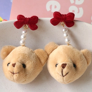 Détail d'une breloque ours en peluche avec nœud rouge et perles pour bijoux DIY