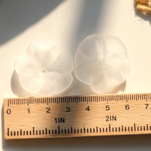 Macro shot of 3cm white frosted acrylic lotus flower charms with detailed petal textures