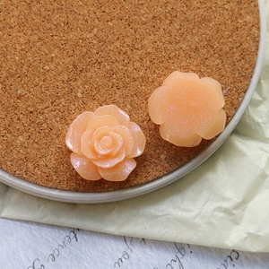 Detailed macro view of two pink resin rose flower charms with subtle glitter finish