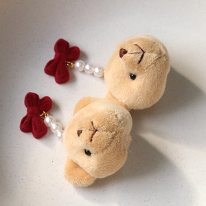 Détail de breloque ours en peluche avec perles blanches et nœud en velours rouge