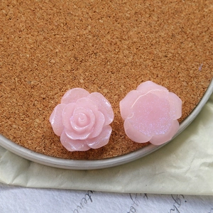 Macro shot of pink pearlescent resin rose charms for DIY jewelry and accessories crafting