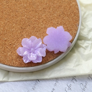 Macro view of light purple resin flower charms with fine glitter for DIY jewelry making