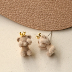 Detail of plush brown teddy bear earrings with golden crowns and soft flocked texture