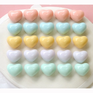 Makroaufnahme von 3D-Macaron-Herzperlen aus Harz in Pastellfarben auf einem Tablett