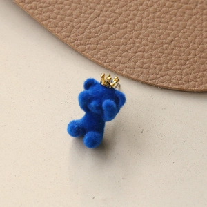 Close-up of a blue flocked teddy bear charm with a gold crown for DIY accessory crafts