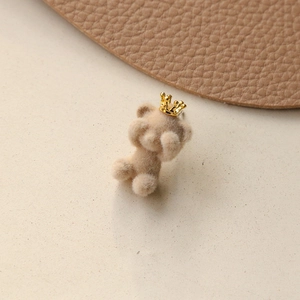 Detail of light brown flocked bear charm with a golden crown in cute peek-a-boo pose