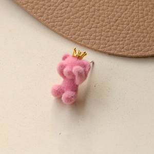 Close-up of pink flocked crown bear earring with soft texture and golden detail