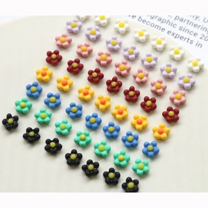 Colorful resin flower nail art charms with yellow centers in various pastel colors