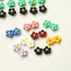 Detailed view of colorful resin daisy charms for DIY nail art and phone case decoration