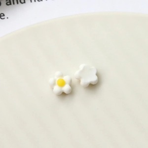 Macro shot of white daisy resin flower accessories for DIY nail art and jewelry making
