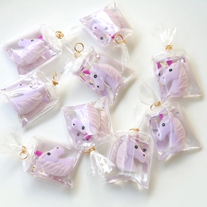 Detail view of purple resin unicorn charms individually packed in clear plastic bags