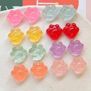 Detalle macro de dijes de resina traslúcida con forma de pata de gato y purpurina DIY